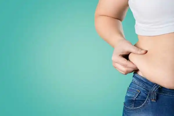 Image of woman pinching her love handles to show weight gain Nottinghamshire
